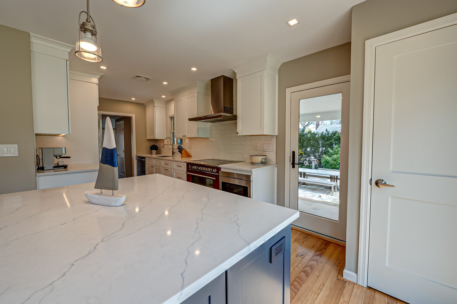 Kitchen renovation with white cabinets and patio access in Stony Brook, NY by Long Island Creative Contracting, Inc
