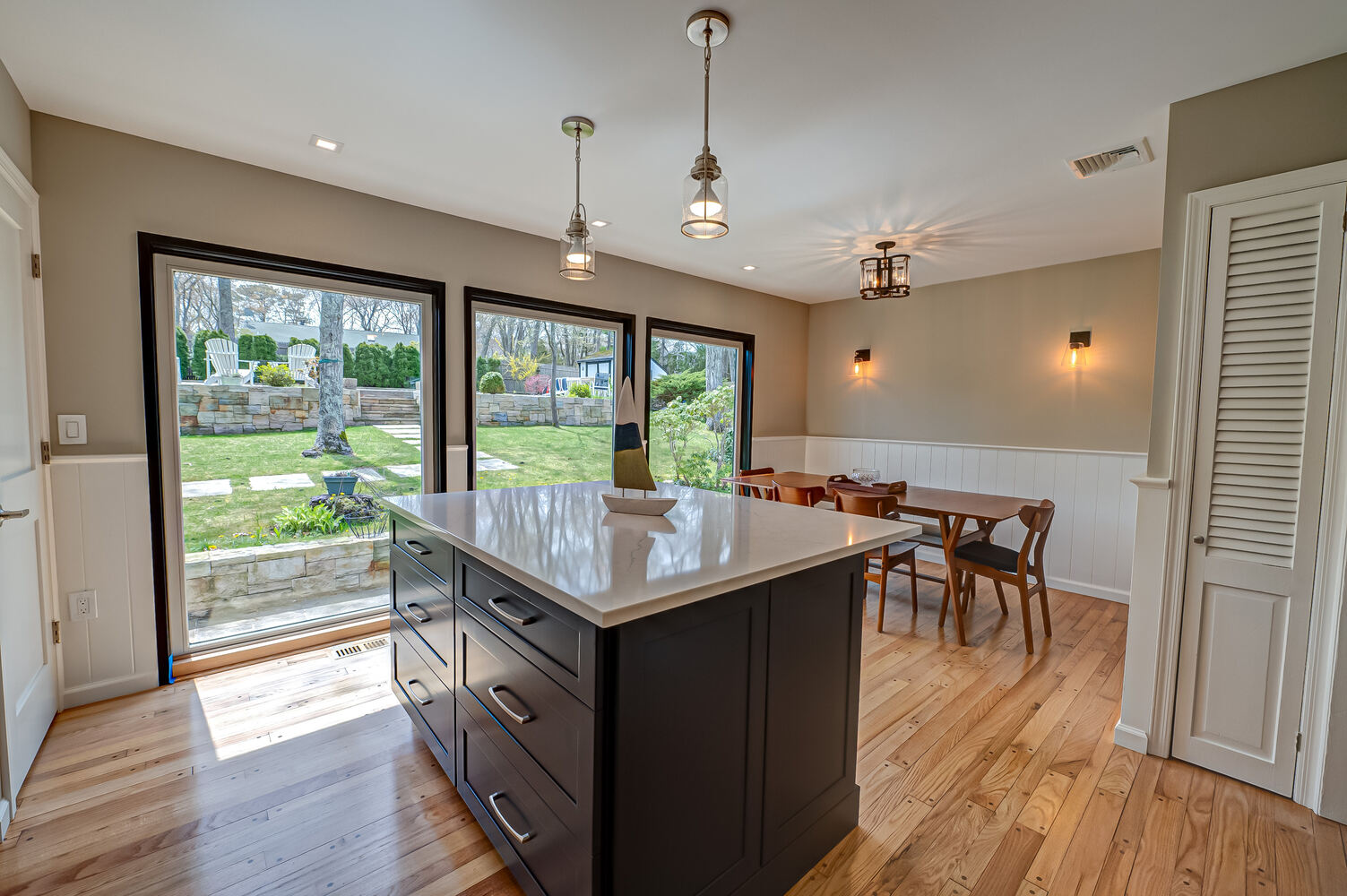 Modern kitchen island with garden views in Remsenberg, NY by Long Island Creative Contracting, Inc