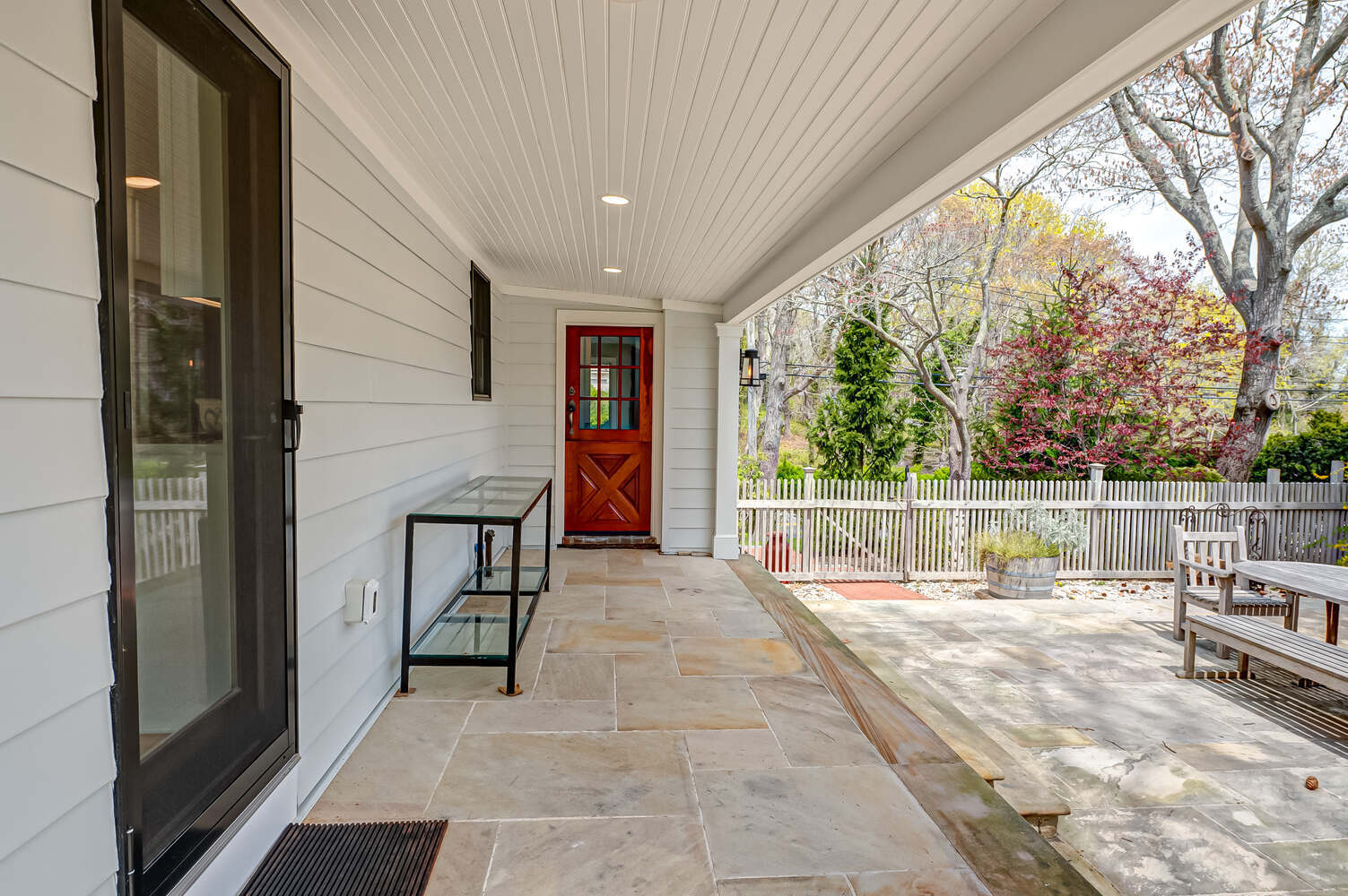 Rear entry and patio area with scenic backyard in Miller Place, NY