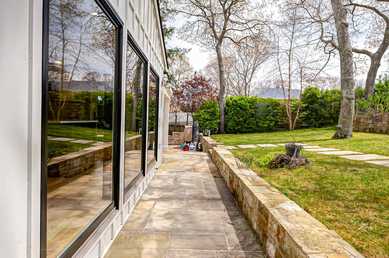Rear walkway beside custom home showcasing outdoor lighting and clean landscaping