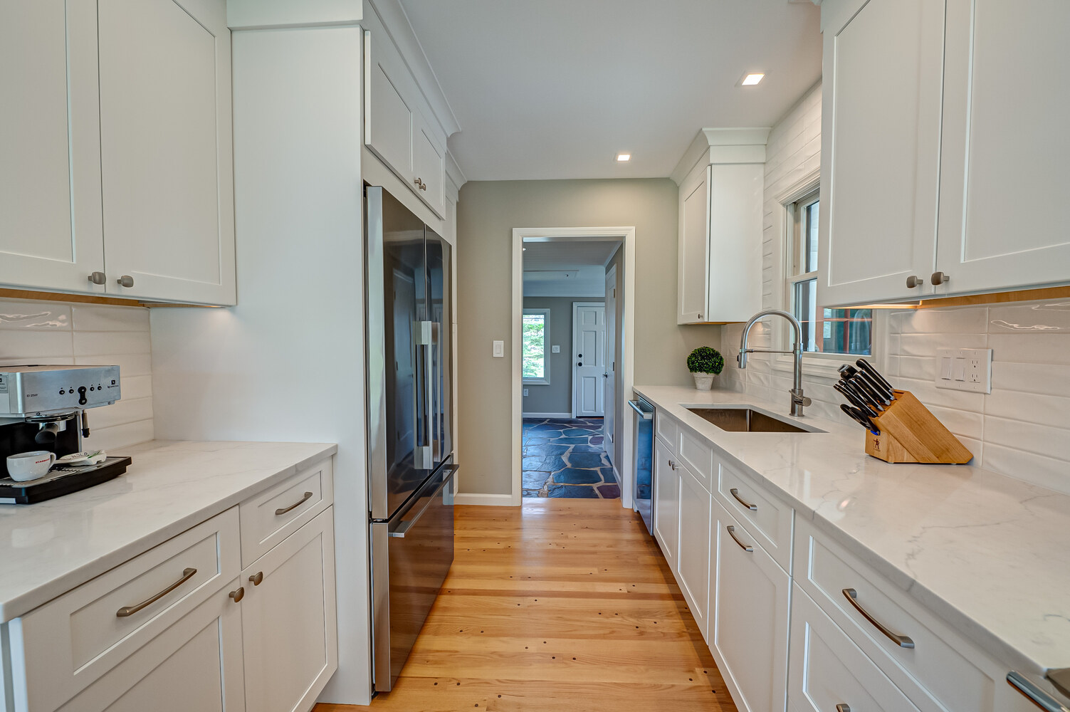 Remodeled kitchen with modern white cabinetry by Long Island Creative Contracting, Inc. in East Setauket, NY