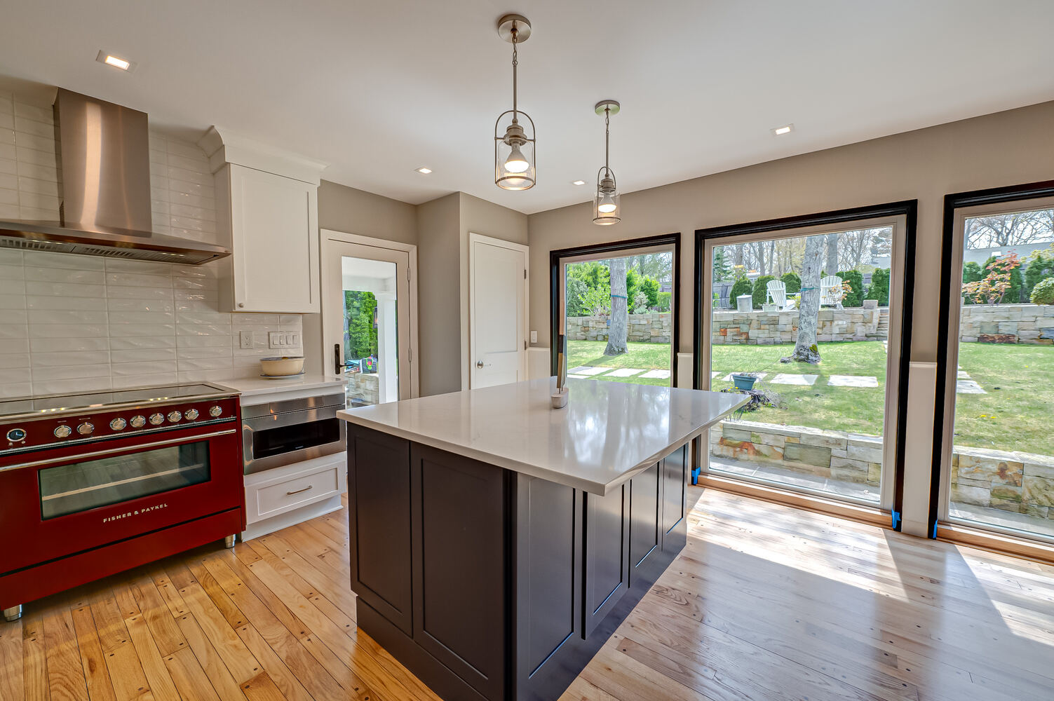Updated custom kitchen with large island and outdoor views in Port Jefferson, NY by Long Island Creative Contracting, Inc