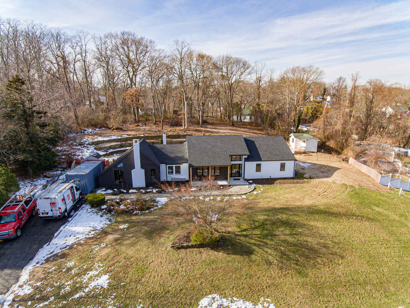 Wide aerial shot of modern custom home and wooded property in Suffolk County, NY