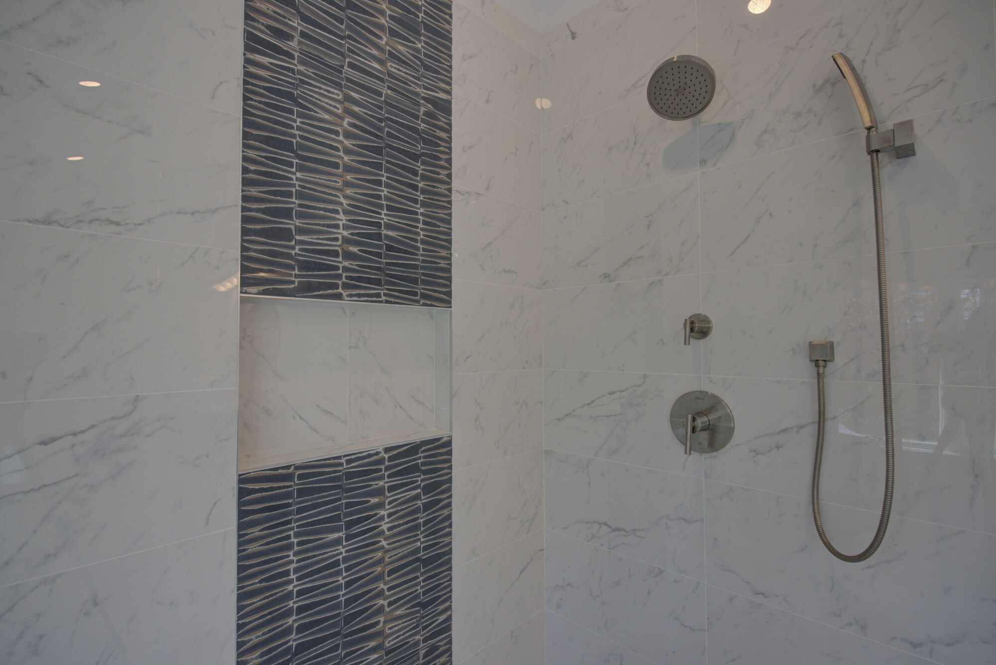 Detailed shower wall with modern tile in a custom bathroom by Long Island Creative Contracting, Inc. in Miller Place, NY