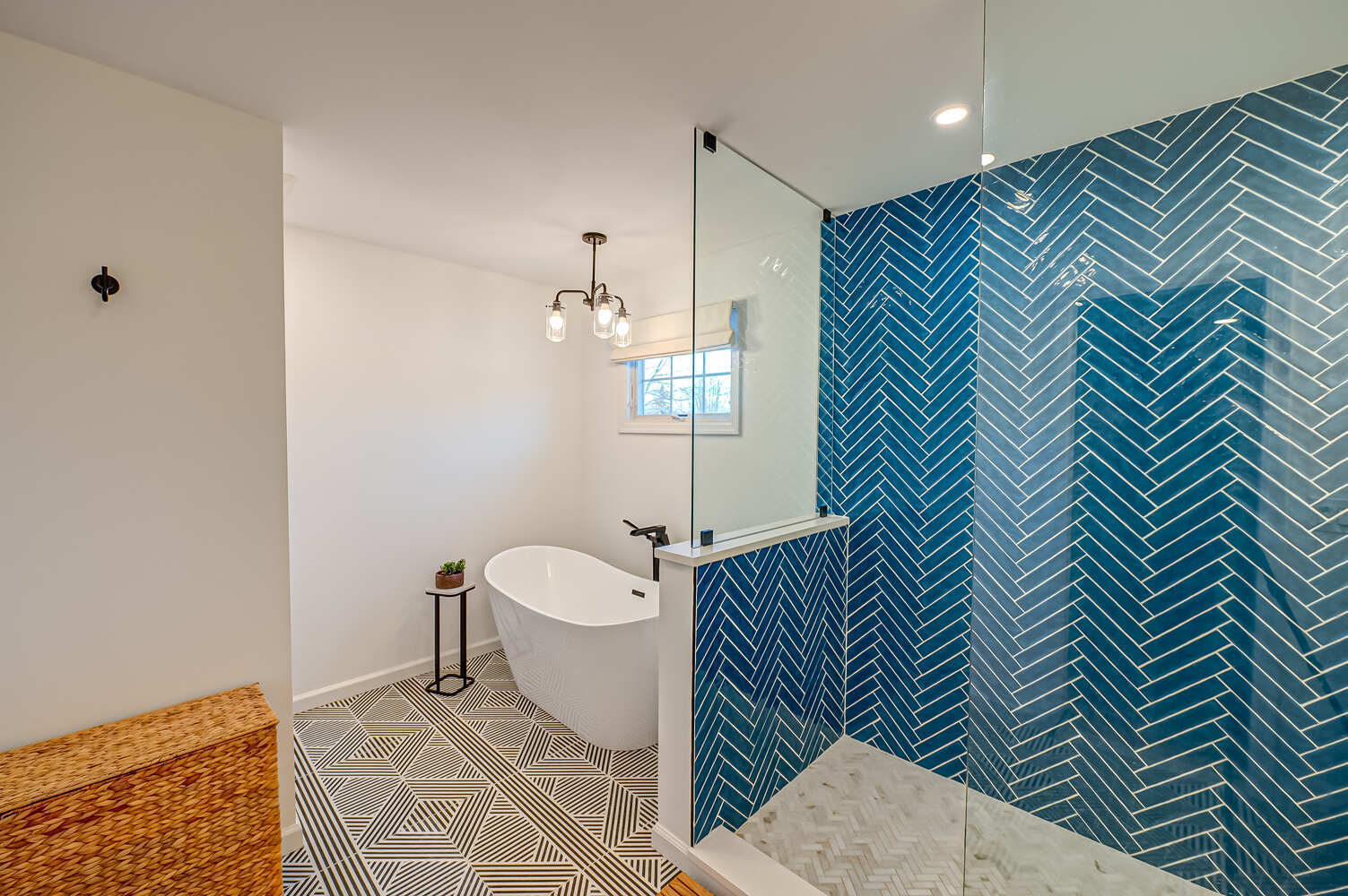 Master bathroom with freestanding tub and bold tile accent wall by Long Island Creative Contracting, Inc