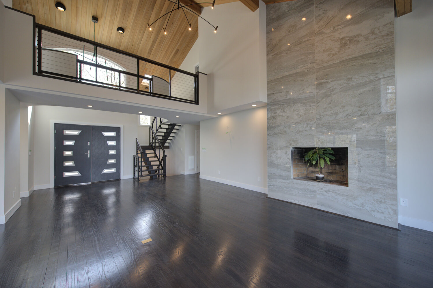 Grand entryway with double doors and modern staircase in a Suffolk County, NY custom home build by Long Island Creative Contracting, Inc