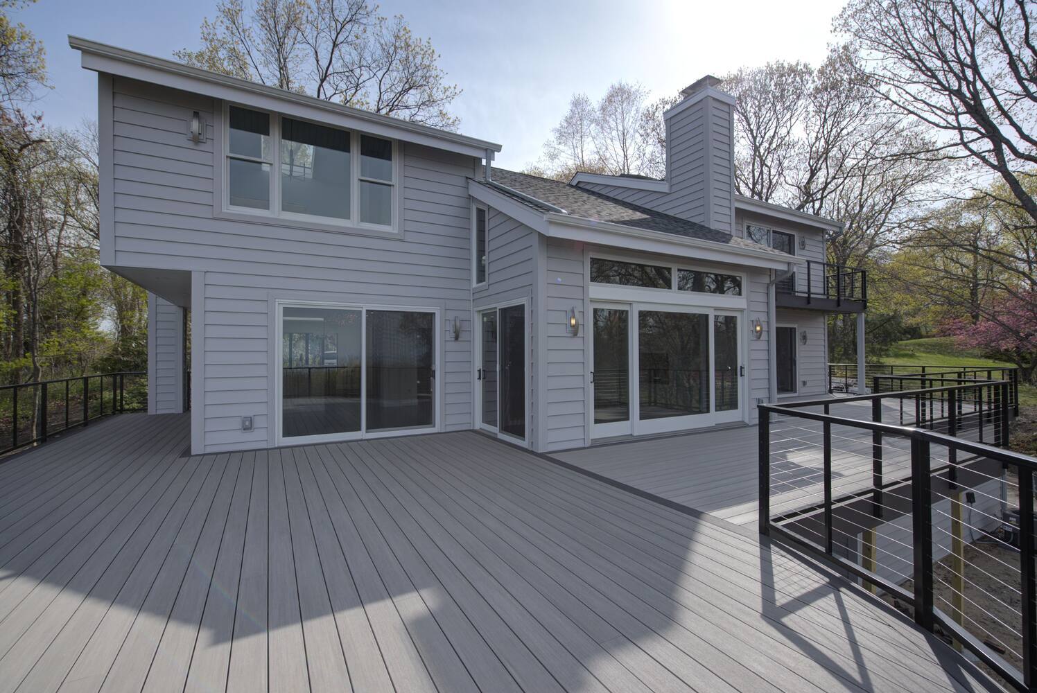 Transitional deck space with sliding glass door access in a Suffolk County, NY custom home