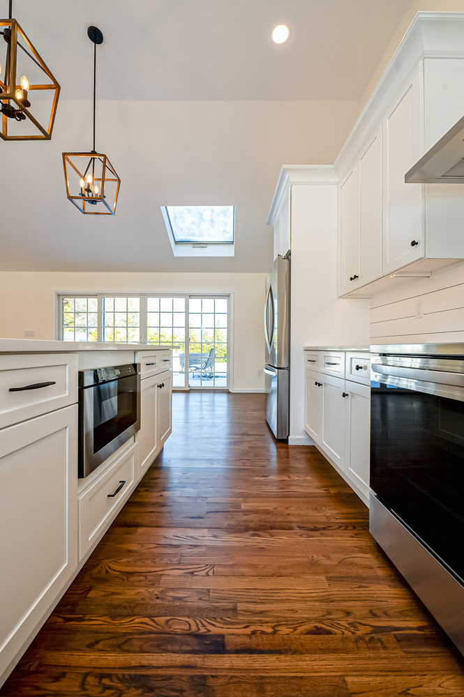 White kitchen with dual ovens and quartz countertops by Long Island Creative Contracting, Inc. in Setauket, NY