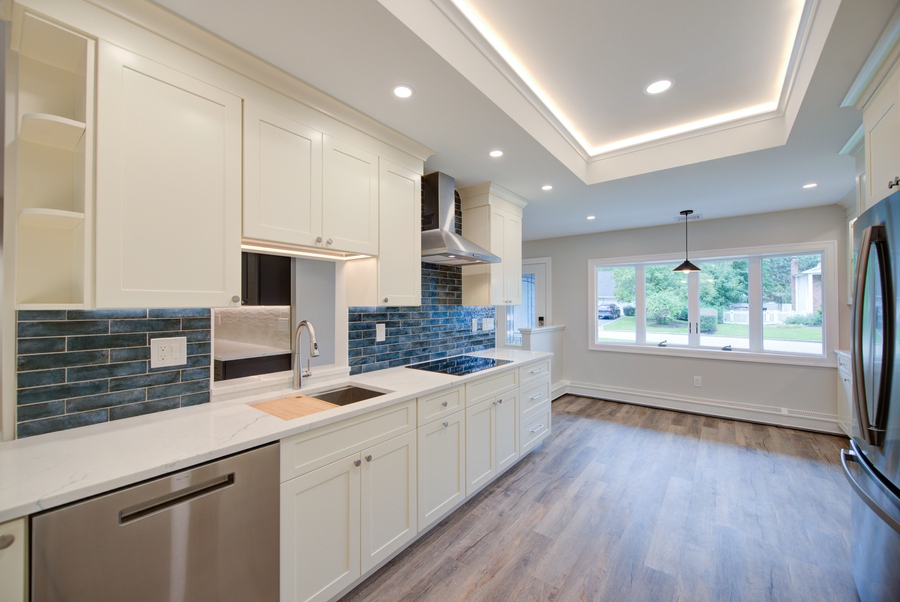 Spacious white kitchen featuring blue tile backsplash and LED ceiling in Huntington, NY