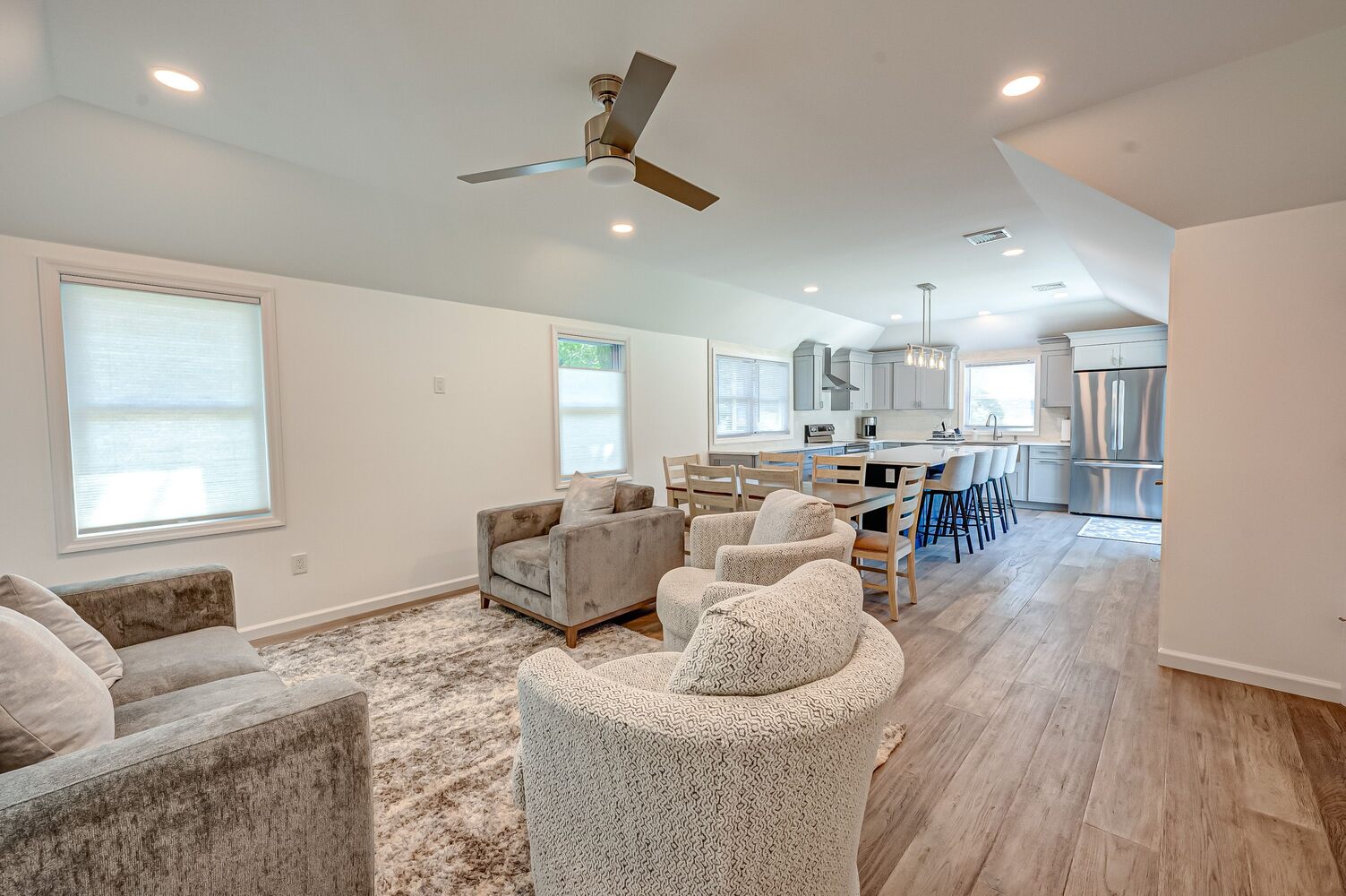 Living room and dining area with wood flooring and ceiling fan in a Long Island Creative Contracting custom build in Stony Brook, NY