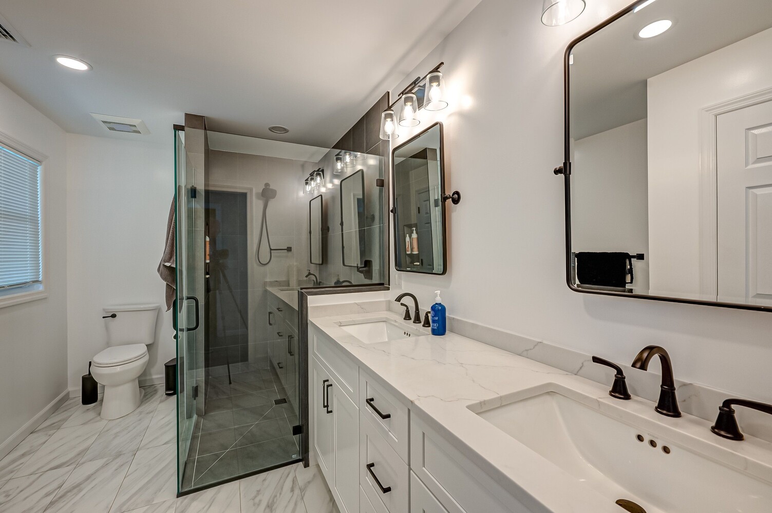 Luxury primary bathroom with dual vanities and glass shower in a custom home by Long Island Creative Contracting in Woodbury, NY