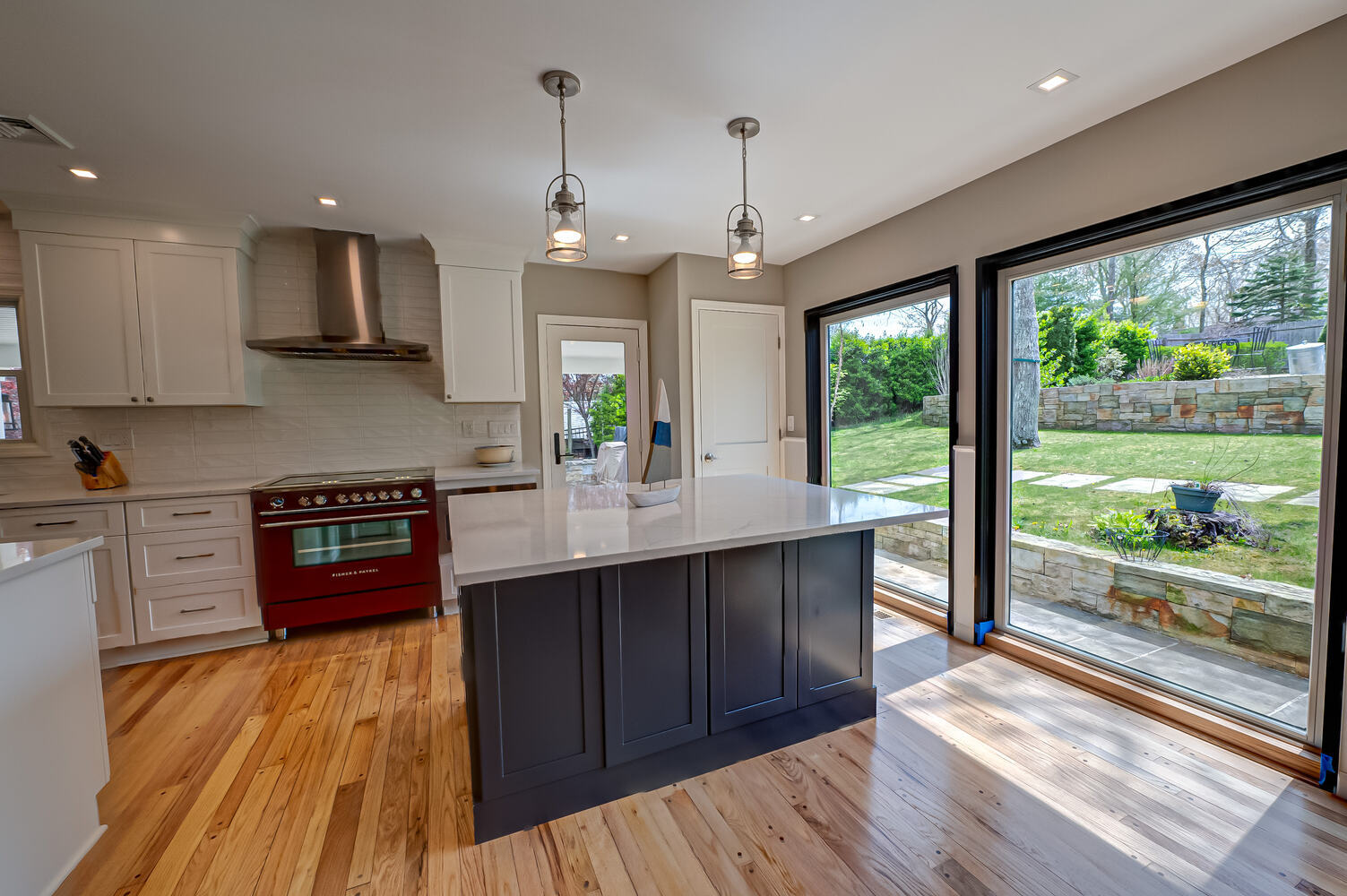 Custom kitchen remodel featuring red appliances and natural light in Suffolk County, NY by Long Island Creative Contracting, Inc