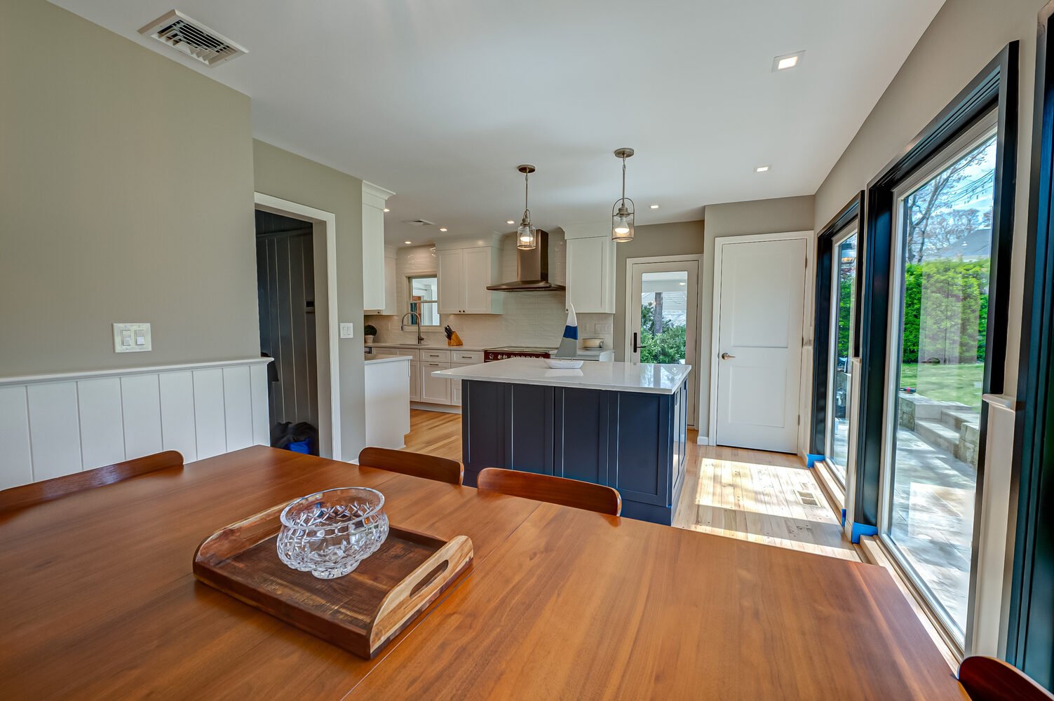 Dining table with kitchen view in custom home remodel in Centereach, NY by Long Island Creative Contracting, Inc