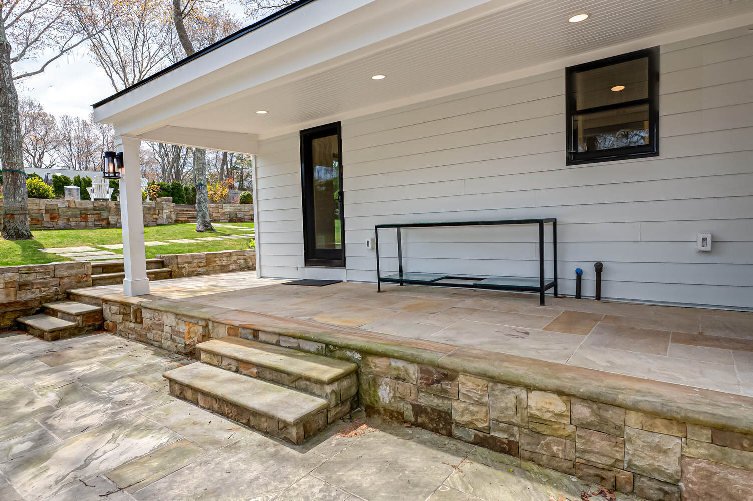 Stone patio and steps leading to custom porch renovation by Long Island Creative Contracting in Miller Place, NY