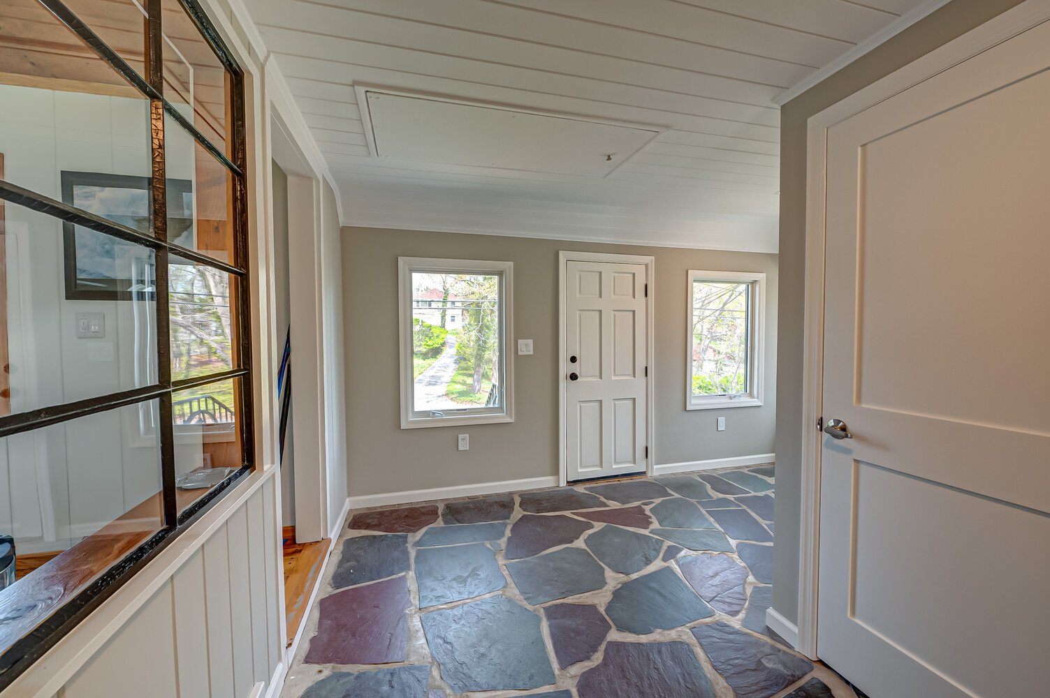 Transitional area with natural light and durable stone floor in a Miller Place custom home project